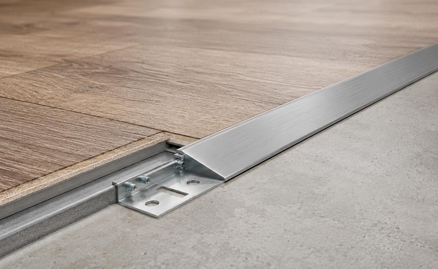 Track-and-insert metal floor transition system installed between wood-effect vinyl flooring and grey floor surface