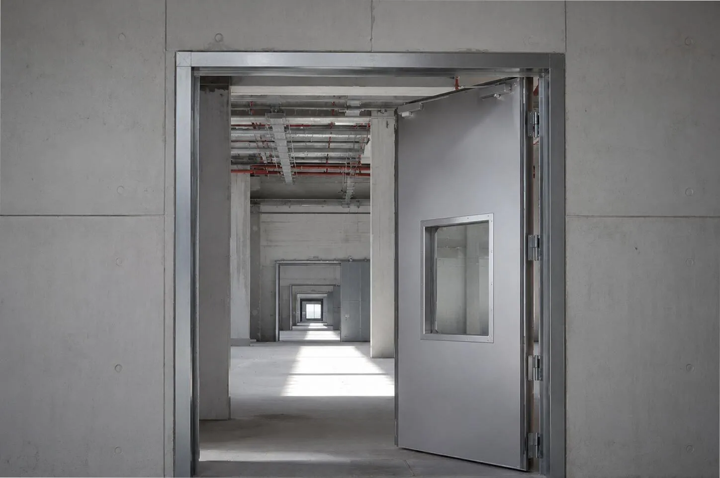 Fire-rated steel door frame installed in a technical corridor of a commercial building